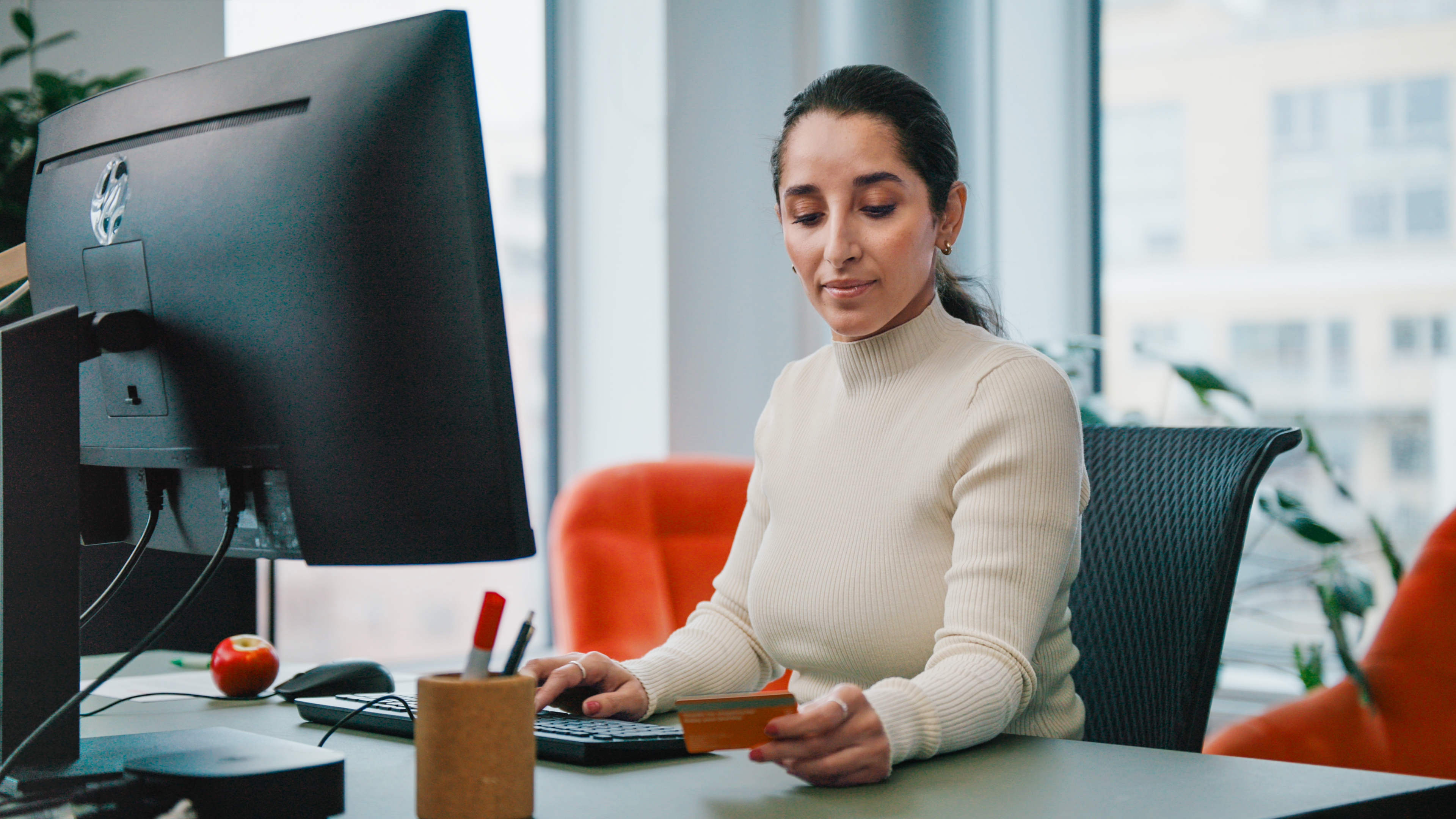 Woman at desk, looking at her Circle K Pro card