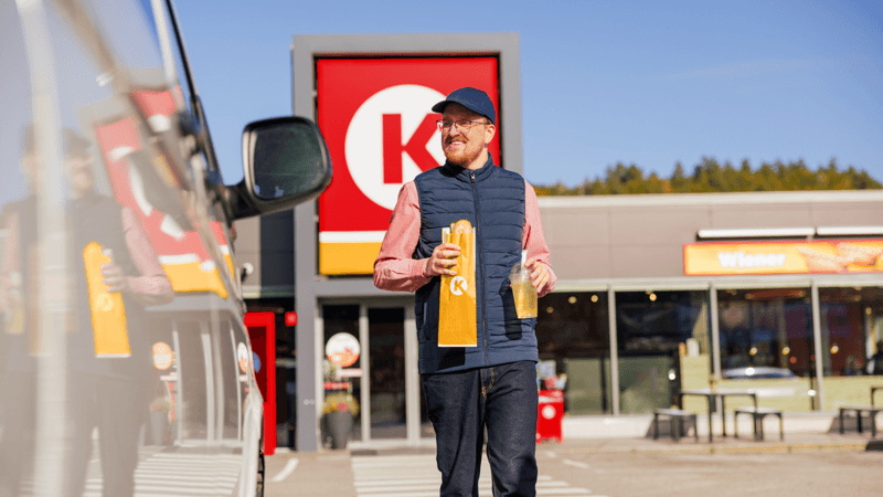 Homme sortant d'une station-service avec ses achats
