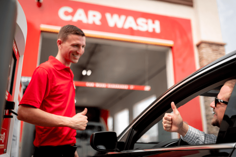 Employé de station de lavage et client qui échangent